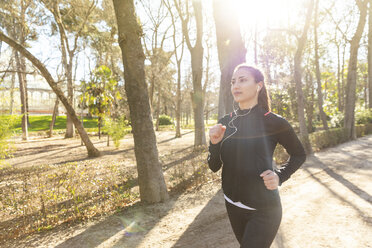 Junge Frau joggt im Park - WPEF01431