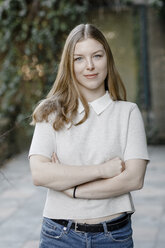 Portrait of self-confident teenage girl standing on terrace - KMKF00801