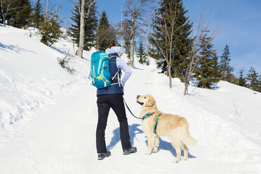 Deutschland, Bayerischer Wald, Lusen, Frau mit Hund beim Wandern im Winter - MAEF12829