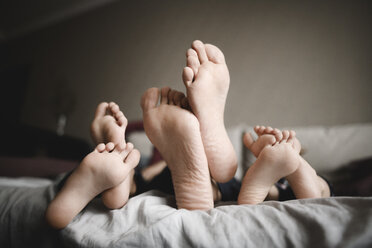 Feet of father and his children relaxing together at home - EYAF00068