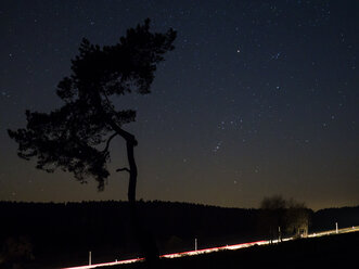 Deutschland, Bayern, Nabburg, Sternenhimmel mit Baum- und Lichtspuren - HUSF00030