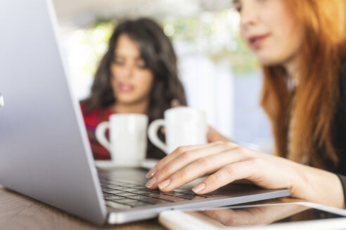 Frauenhand arbeitet am Laptop in einem Straßencafé, Nahaufnahme - WPEF01440