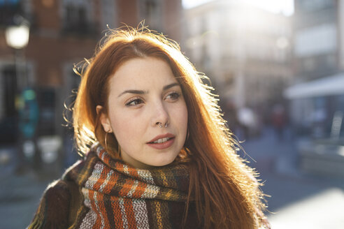 Porträt einer rothaarigen jungen Frau mit Nasenpiercing in der Stadt - WPEF01447