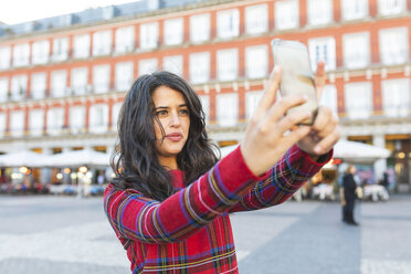 Spain, Madrid, Plaza Mayor, portrait of woman taking selfie with smartphone - WPEF01453