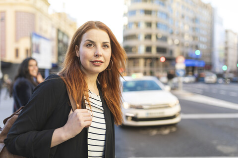 Porträt einer rothaarigen jungen Frau mit Nasenpiercing in der Stadt, lizenzfreies Stockfoto