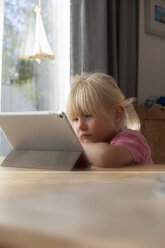 Porträt eines traurigen kleinen Mädchens, das zu Hause ein digitales Tablet benutzt - GAF00103