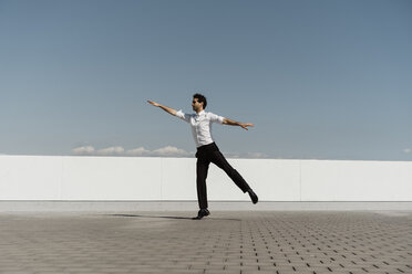 Balletttänzerin mit Kopfhörern beim Üben auf der Dachterrasse - AFVF02693