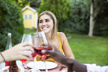 Freunde stoßen mit Wein bei einem Sommeressen im Garten an - ABZF02278