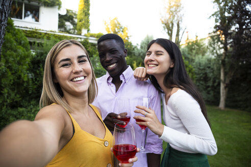 Friends having fun at a summer dinner in the garden, taking selfies - ABZF02287