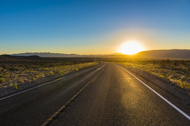 USA, Nevada, Lange kurvenreiche Straße bei Sonnenuntergang - RUNF01686