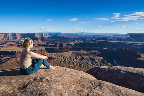 USA, Utah, Frau an einem Aussichtspunkt mit Blick auf die Canyonlands und den Colorado River im Dead Horse State Park - RUNF01691