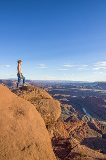 USA, Utah, Woman at a overlook over the canyonlands and the Colorado river from the Dead Horse State Park - RUNF01694