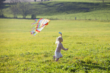 Little girl running in field with kite - GAF00117