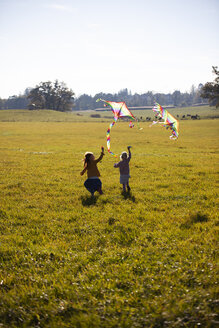 Zwei Mädchen laufen im Feld mit Drachen - GAF00121