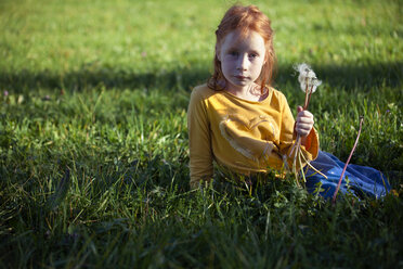 Portrait of girl sitting in field with blowball - GAF00124