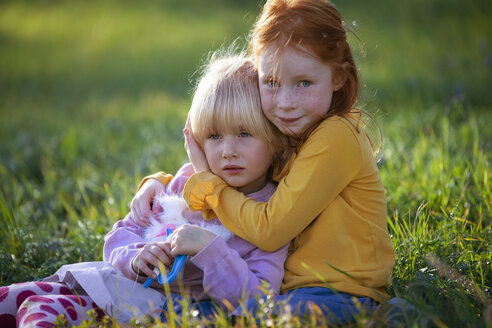 Porträt eines Mädchens, das seine Schwester auf einem Feld umarmt - GAF00128