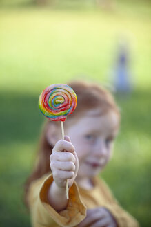Girl holding a colourful lollipop - GAF00130