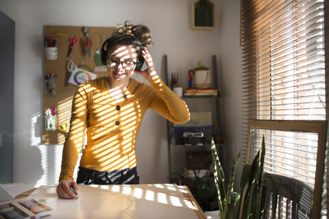 Frau malt und hört Musik, lizenzfreies Stockfoto