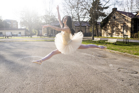 Italien, Verona, Ballerina tanzt in der Stadt und springt in der Luft, lizenzfreies Stockfoto