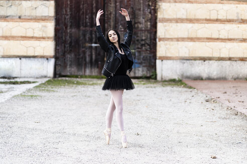 Italien, Verona, Porträt einer in der Stadt tanzenden Ballerina in Lederjacke und Tutu - GIOF05990