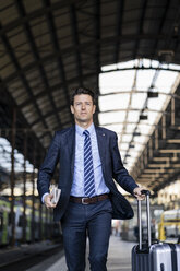 Geschäftsmann mit Koffer auf dem Bahnsteig - DIGF06426