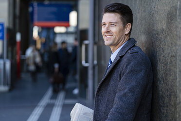 Smiling businessman at a wall - DIGF06461