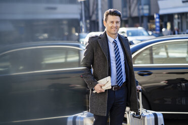 Businessman with suitcase at the street in the city - DIGF06463