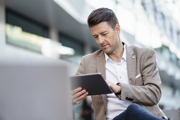 Businessman using tablet outdoors - DIGF06494