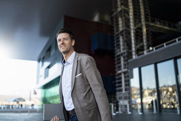 Smiling businessman on the move in the city - DIGF06506