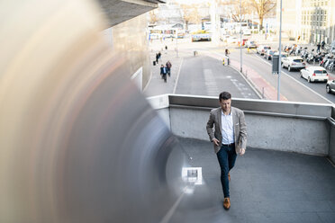 Businessman walking on overpass in the city - DIGF06513