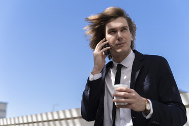 Italien, Florenz, junger Geschäftsmann mit Smartphone im Freien - FMOF00504