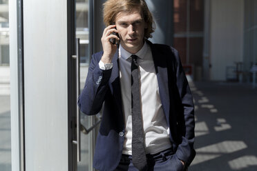 Italy, Florence, young businessman on smartphone outdoor - FMOF00513