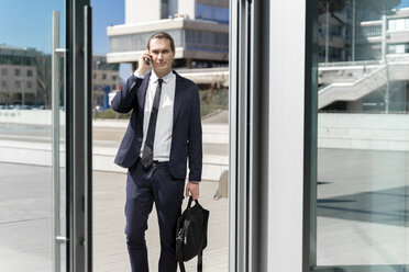 Italy, Florence, young businessman on smartphone outdoor - FMOF00517