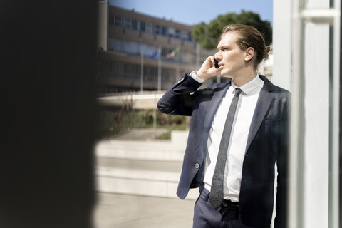 Italien, Florenz, junger Geschäftsmann auf Smartphone im Freien, lizenzfreies Stockfoto