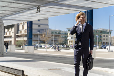 Italy, Florence, young businessman on smartphone outdoor - FMOF00521