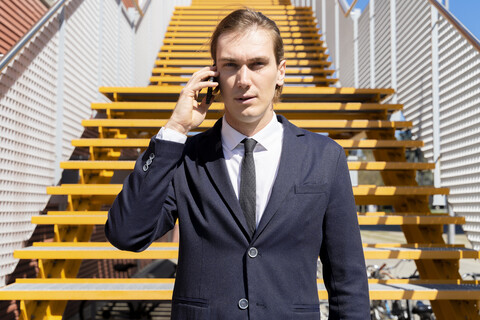 Italien, Florenz, junger Geschäftsmann auf Smartphone im Freien, lizenzfreies Stockfoto