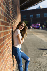 Young woman leaning on brick wall in New York City - GIOF06057