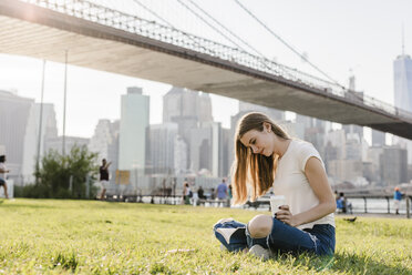 Junge Frau erkundet New York City, macht eine Pause, liest ein Buch - GIOF06063