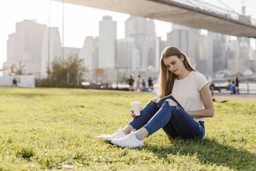 Junge Frau erkundet New York City, macht eine Pause, liest ein Buch - GIOF06064