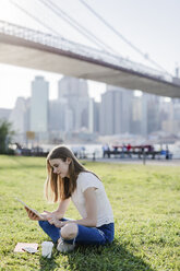 Junge Frau, die New York City erkundet, macht eine Pause und benutzt ein digitales Tablet - GIOF06072