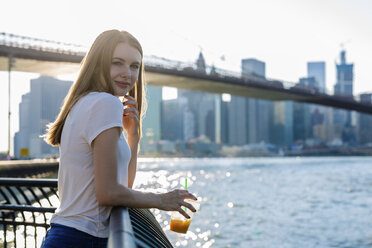 Young woman exploring New York City, looking at Brooklyn Bridge - GIOF06073