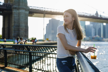 Young woman exploring New York City, looking at Brooklyn Bridge - GIOF06074