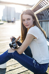 Young woman exploring New York City, taking pictures at Brooklyn Bridge - GIOF06082