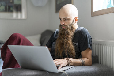 Porträt eines Hipsters, der zu Hause einen Laptop benutzt - AFVF02714