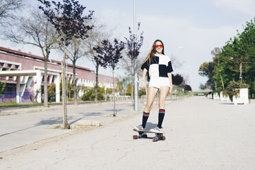 Spanien, jugendliches Mädchen fährt Skateboard auf einer Straße - ERRF00835