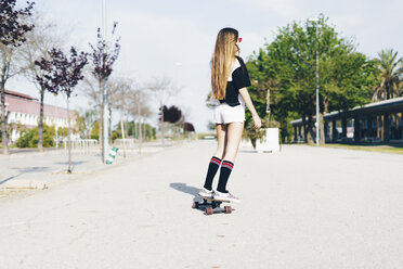 Spanien, jugendliches Mädchen fährt Skateboard auf einer Straße - ERRF00836