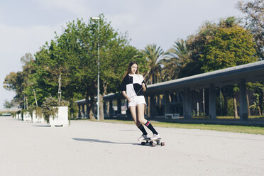 Spanien, jugendliches Mädchen fährt Skateboard auf einer Straße - ERRF00837