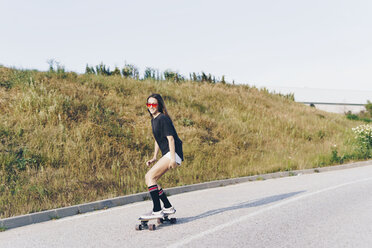 Spanien, jugendliches Mädchen fährt auf einem Skateboard eine Straße hinunter - ERRF00844