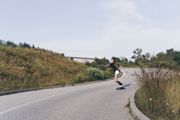 Spanien, jugendliches Mädchen fährt auf einem Skateboard eine Straße hinunter - ERRF00845