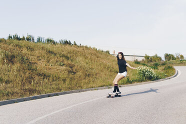 Spanien, jugendliches Mädchen fährt auf einem Skateboard eine Straße hinunter - ERRF00846